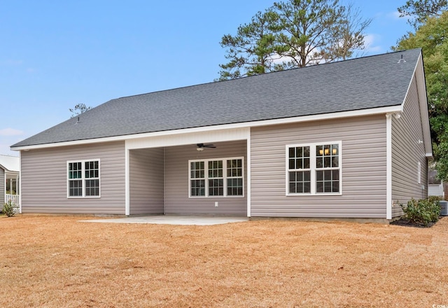 back of property with central air condition unit, a yard, roof with shingles, ceiling fan, and a patio area