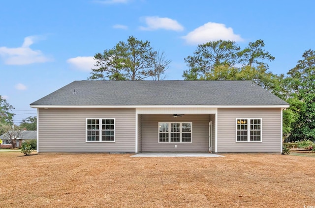 back of house with a yard, a patio, ceiling fan, and roof with shingles