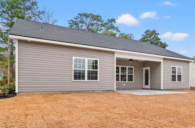 back of property featuring a lawn, a patio, ceiling fan, and roof with shingles