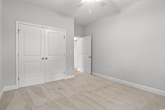 unfurnished bedroom with a closet, carpet flooring, ceiling fan, and baseboards