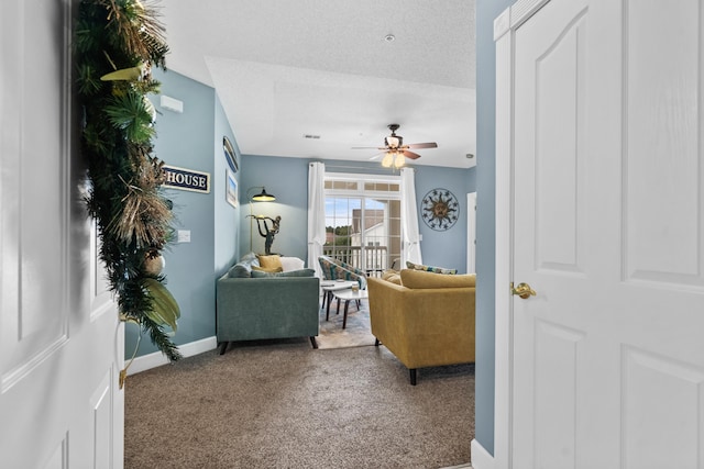 living room with carpet floors, a textured ceiling, and ceiling fan