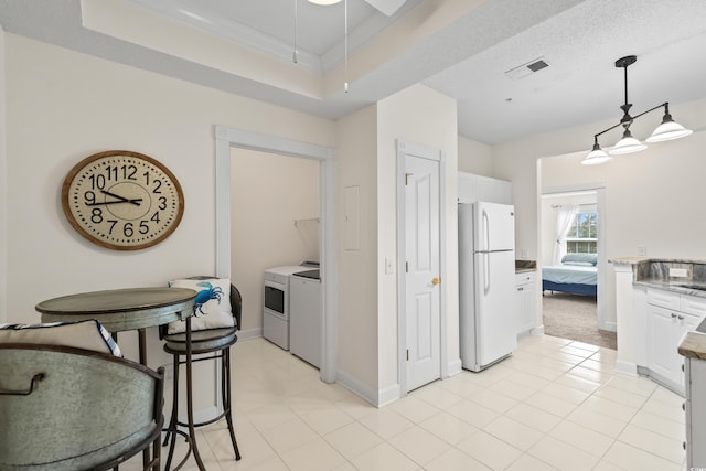2241 Waterview Dr Unit 437, North Myrtle Beach, SC 29582 - kitchen featuring freestanding refrigerator, washing machine and clothes dryer, white cabinetry, baseboards, and pendant lighting