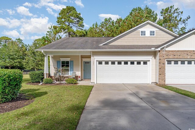 view of front of property featuring a front lawn, covered porch, and a garage