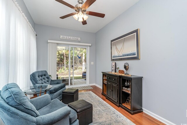 living area featuring ceiling fan and light hardwood / wood-style floors