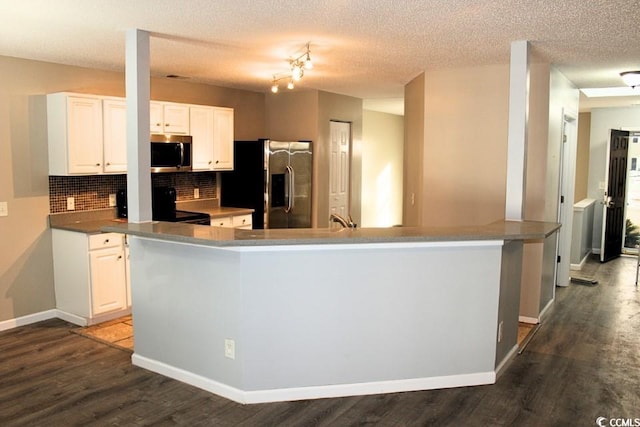 kitchen featuring tasteful backsplash, dark hardwood / wood-style flooring, white cabinets, and appliances with stainless steel finishes