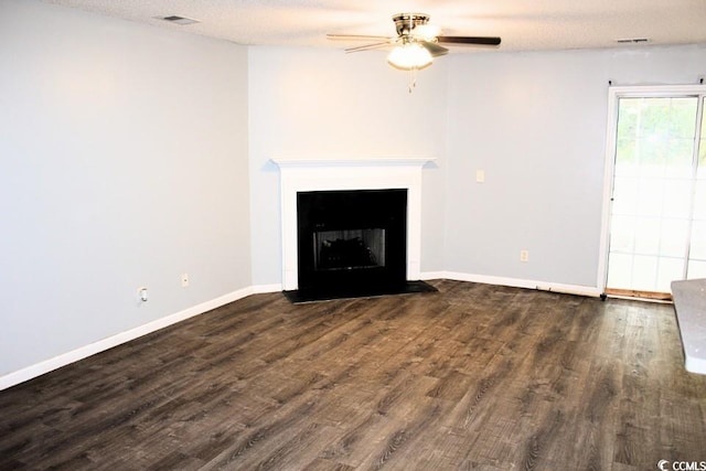 unfurnished living room featuring ceiling fan, dark hardwood / wood-style flooring, and a textured ceiling