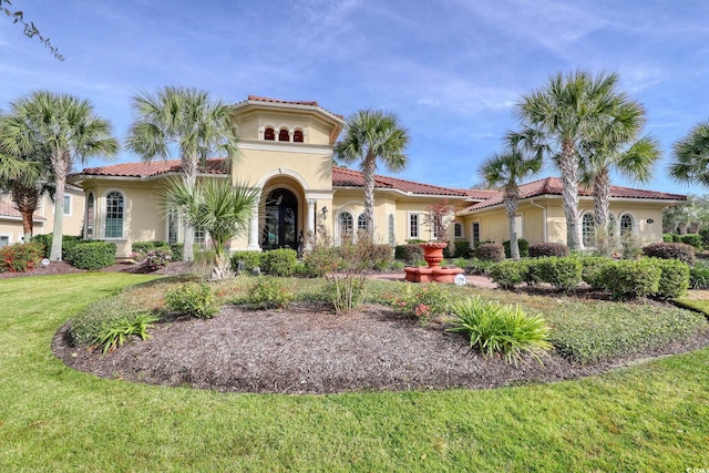 mediterranean / spanish-style home with a front lawn