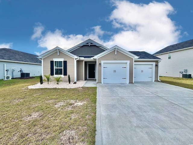 view of front of property featuring a front lawn, a garage, and central AC unit