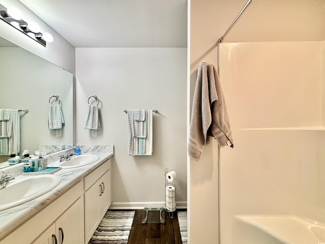 bathroom with vanity, wood-type flooring, and walk in shower