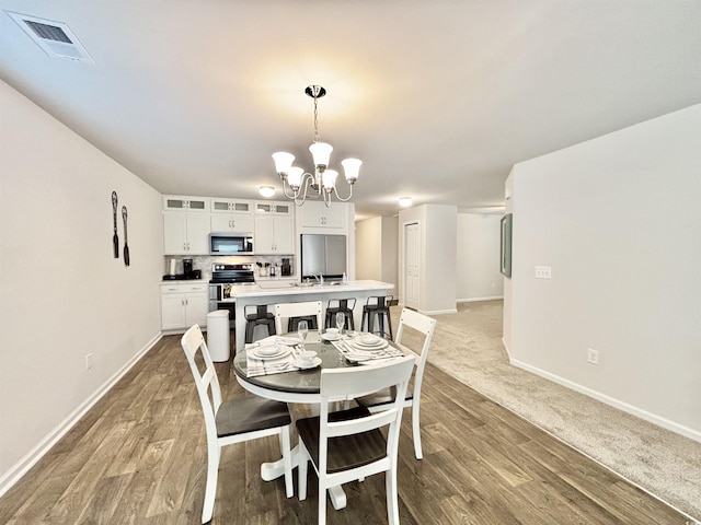 dining area featuring hardwood / wood-style floors and an inviting chandelier