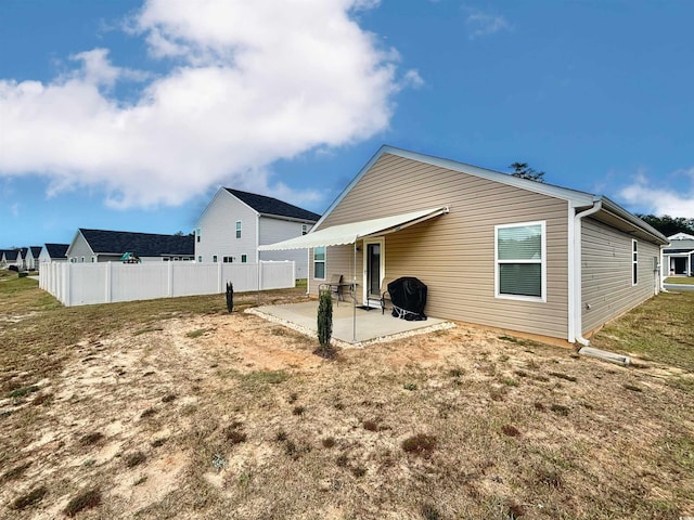 rear view of house with a lawn and a patio area