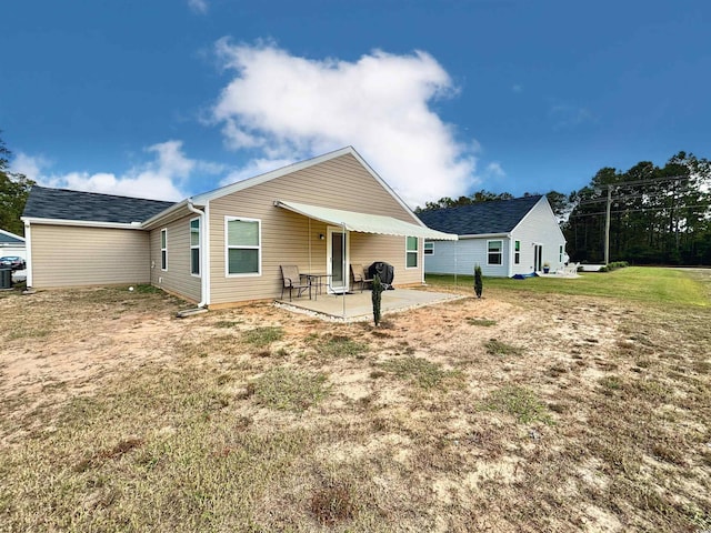 rear view of property with a yard, a patio, and central AC unit