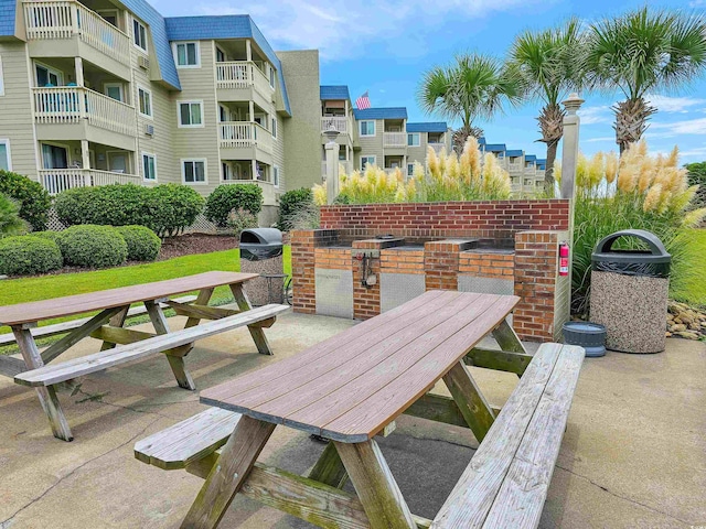 view of patio featuring a grill and a balcony