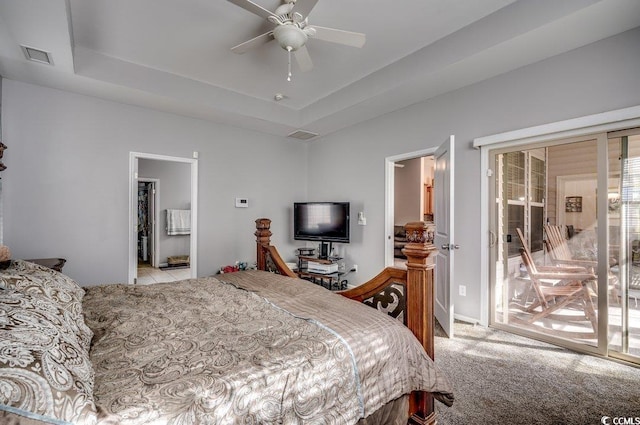 bedroom featuring ceiling fan, light colored carpet, access to outside, and a tray ceiling