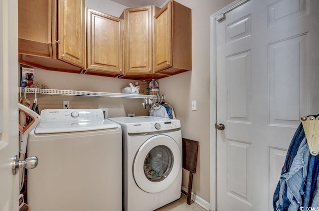 washroom featuring washer and clothes dryer and cabinets