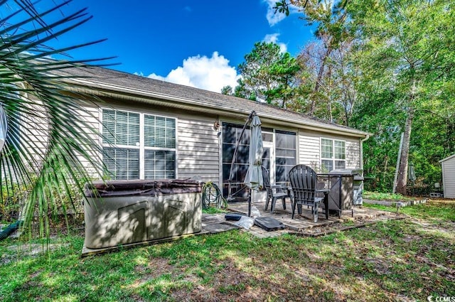 rear view of house featuring a hot tub