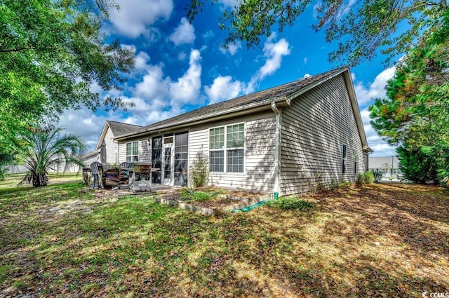 rear view of house featuring a lawn