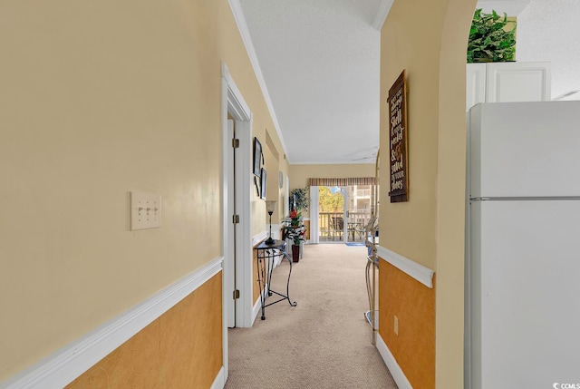 hall with light carpet and ornamental molding