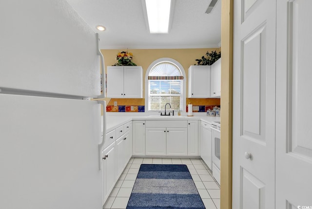 kitchen with white appliances, white cabinetry, light tile patterned flooring, and ornamental molding