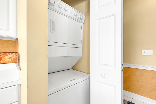 laundry area featuring tile patterned floors and stacked washer / drying machine