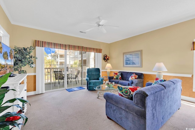 carpeted living room featuring ornamental molding and ceiling fan