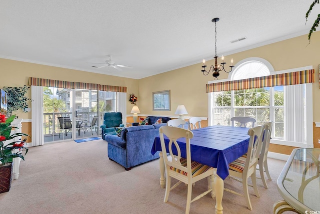 dining area with a textured ceiling, ceiling fan with notable chandelier, light carpet, and crown molding