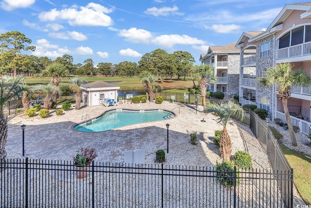 view of pool featuring an outbuilding and a patio area