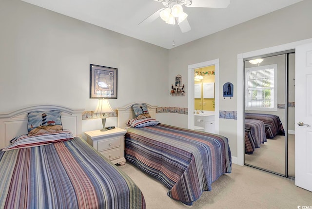 bedroom with ceiling fan, ensuite bath, a closet, and light colored carpet