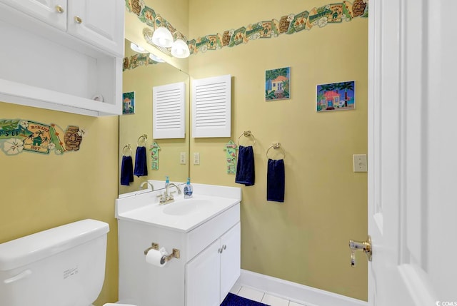 bathroom with toilet, vanity, and tile patterned flooring