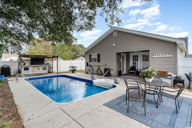 view of pool with an outdoor kitchen and a patio