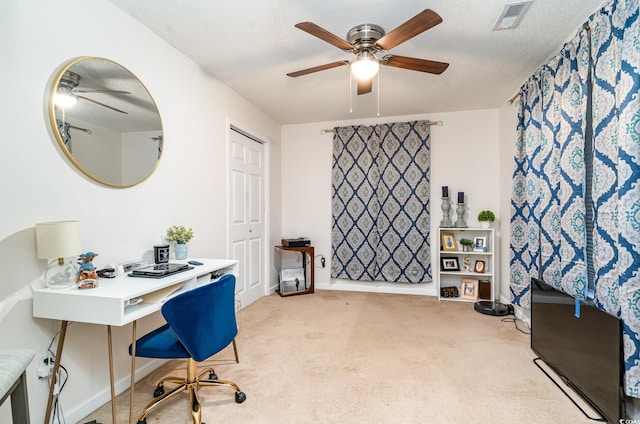 carpeted home office featuring ceiling fan and a textured ceiling