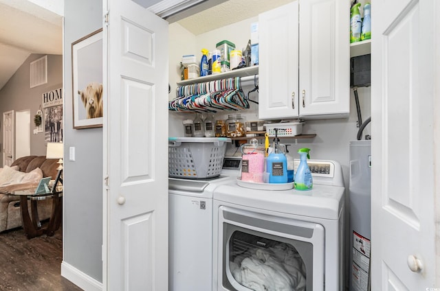 laundry room with cabinets, water heater, dark hardwood / wood-style floors, a textured ceiling, and washer and clothes dryer