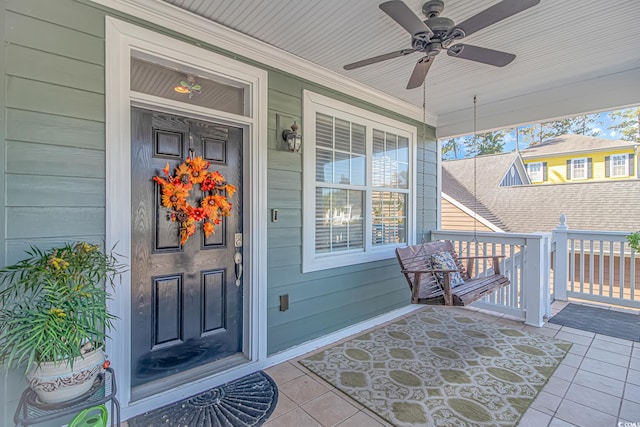 view of exterior entry featuring covered porch and ceiling fan