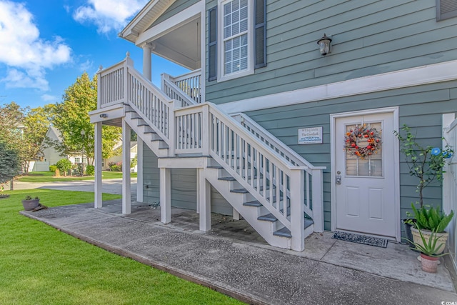 view of exterior entry featuring a lawn