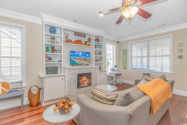 living room with hardwood / wood-style floors, a fireplace, and ornamental molding