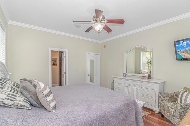 bedroom featuring dark wood-type flooring, ceiling fan, and crown molding