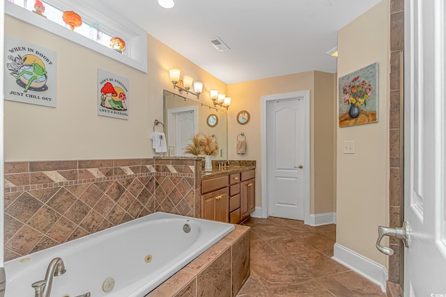 bathroom with tile patterned flooring, vanity, and tiled tub