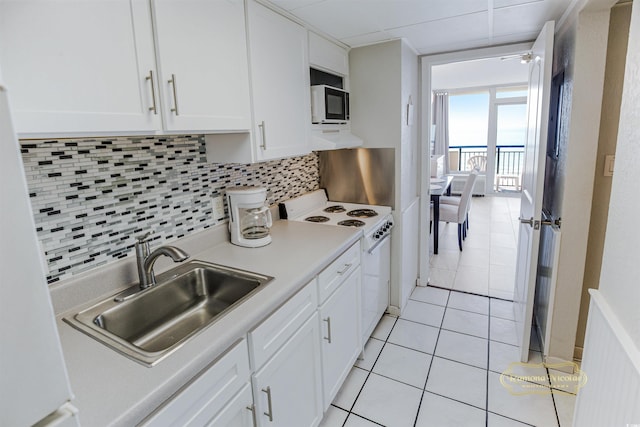 kitchen featuring white cabinets, light tile patterned floors, tasteful backsplash, sink, and white electric range