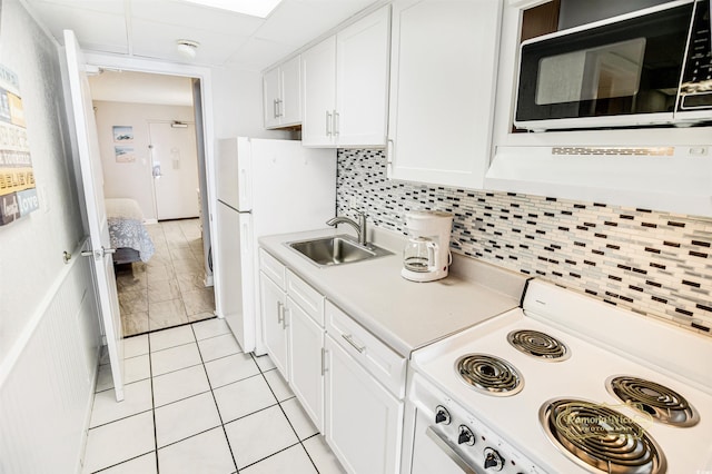 kitchen featuring white cabinetry, backsplash, light tile patterned floors, white range, and sink