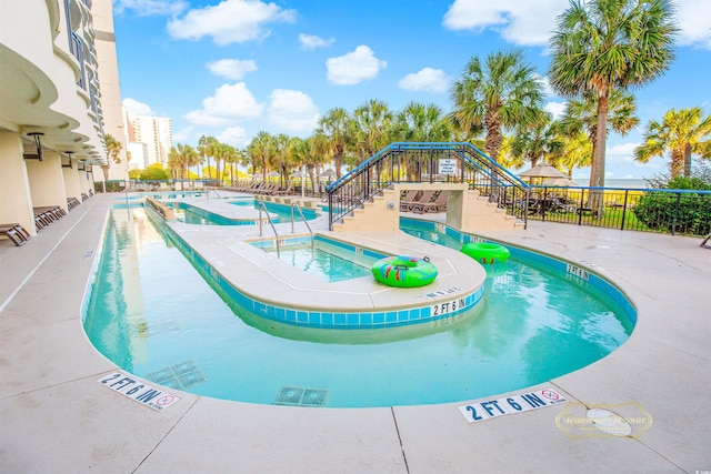 view of swimming pool with a hot tub and a patio