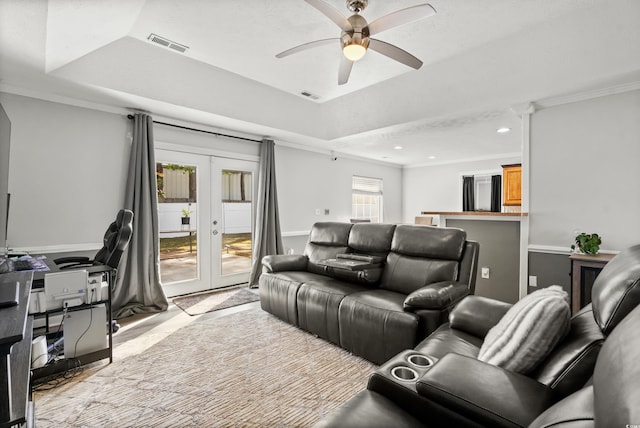 home theater with french doors, a raised ceiling, ceiling fan, and crown molding