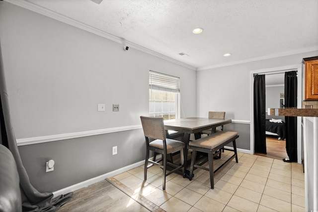 tiled dining area with a textured ceiling and ornamental molding