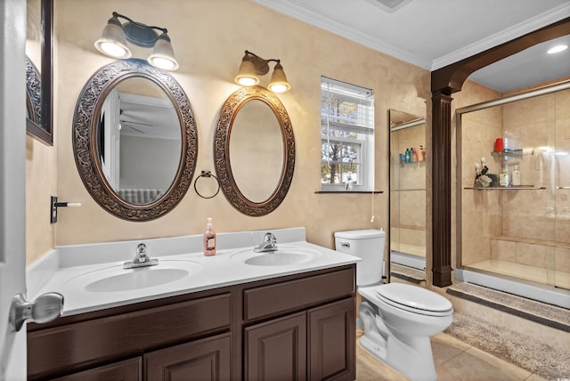 bathroom featuring tile patterned flooring, crown molding, toilet, vanity, and a shower with shower door