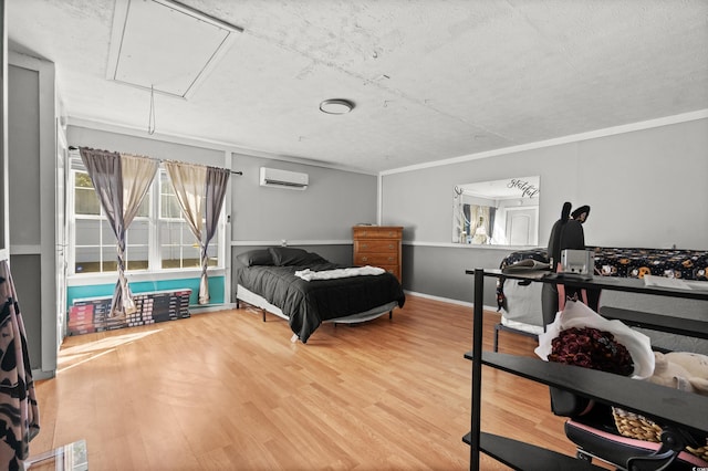 bedroom featuring an AC wall unit, crown molding, and hardwood / wood-style flooring