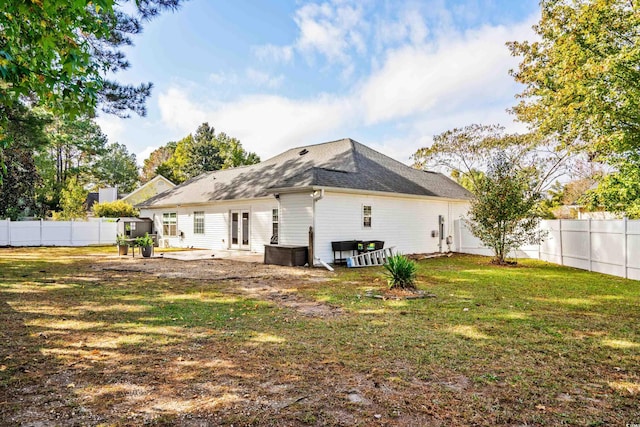 back of house with a lawn and a patio