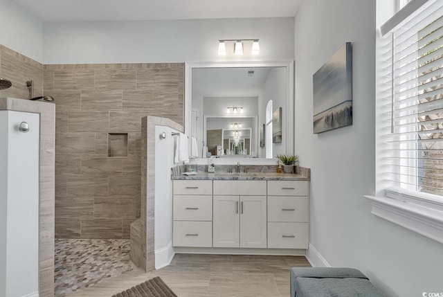 bathroom with vanity and a tile shower