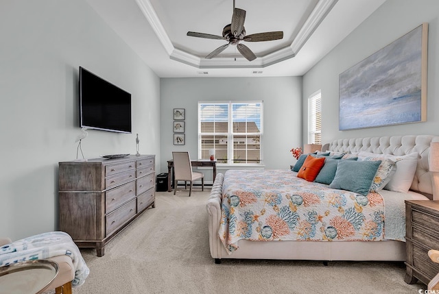 carpeted bedroom with ceiling fan, a raised ceiling, and crown molding