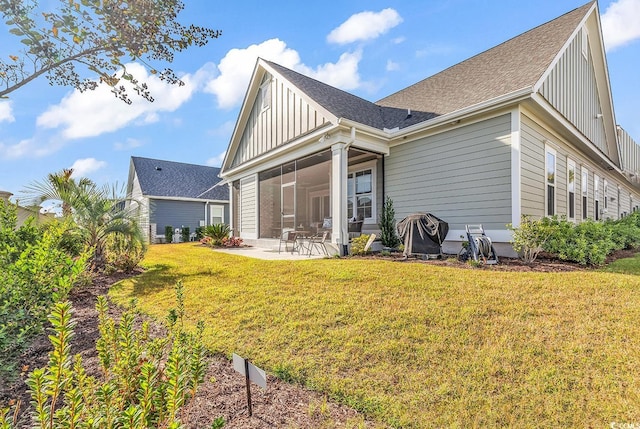 rear view of property with a patio area, a lawn, and a sunroom