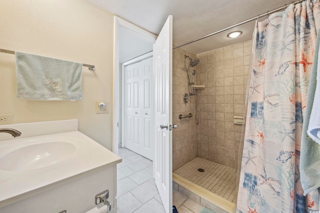 bathroom with tile patterned flooring, vanity, curtained shower, and a textured ceiling