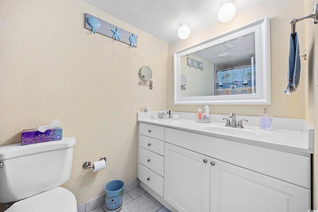 bathroom featuring tile patterned floors, vanity, and toilet